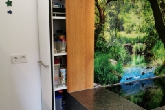tiefer Apotherschrank hinter dem Küchenblock; raumhoch; schwarz durchgefärbter MDF-Schichtstoff